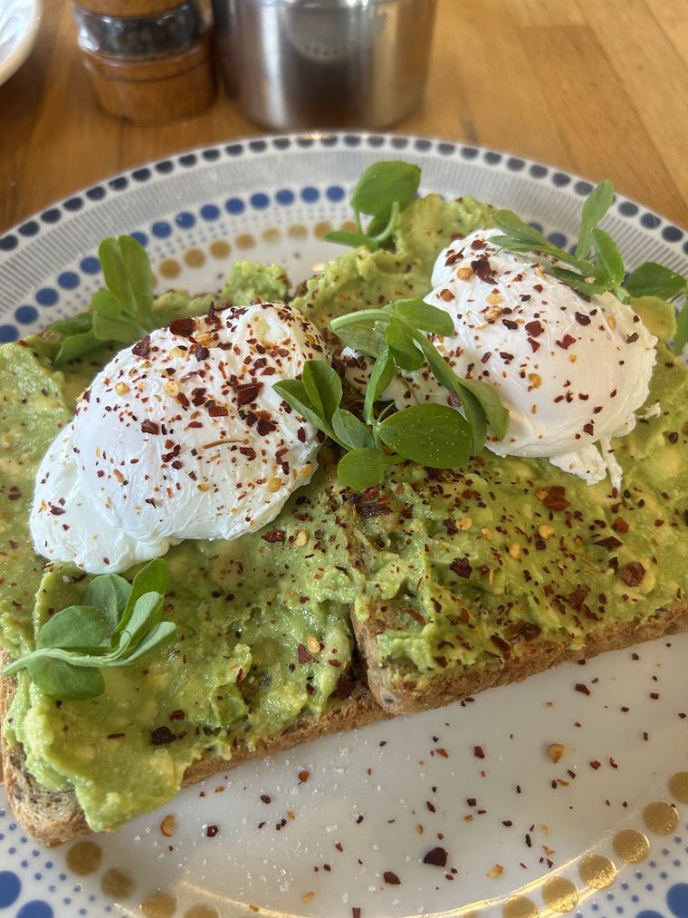 Smashed avocado on toast topped with two poached eggs